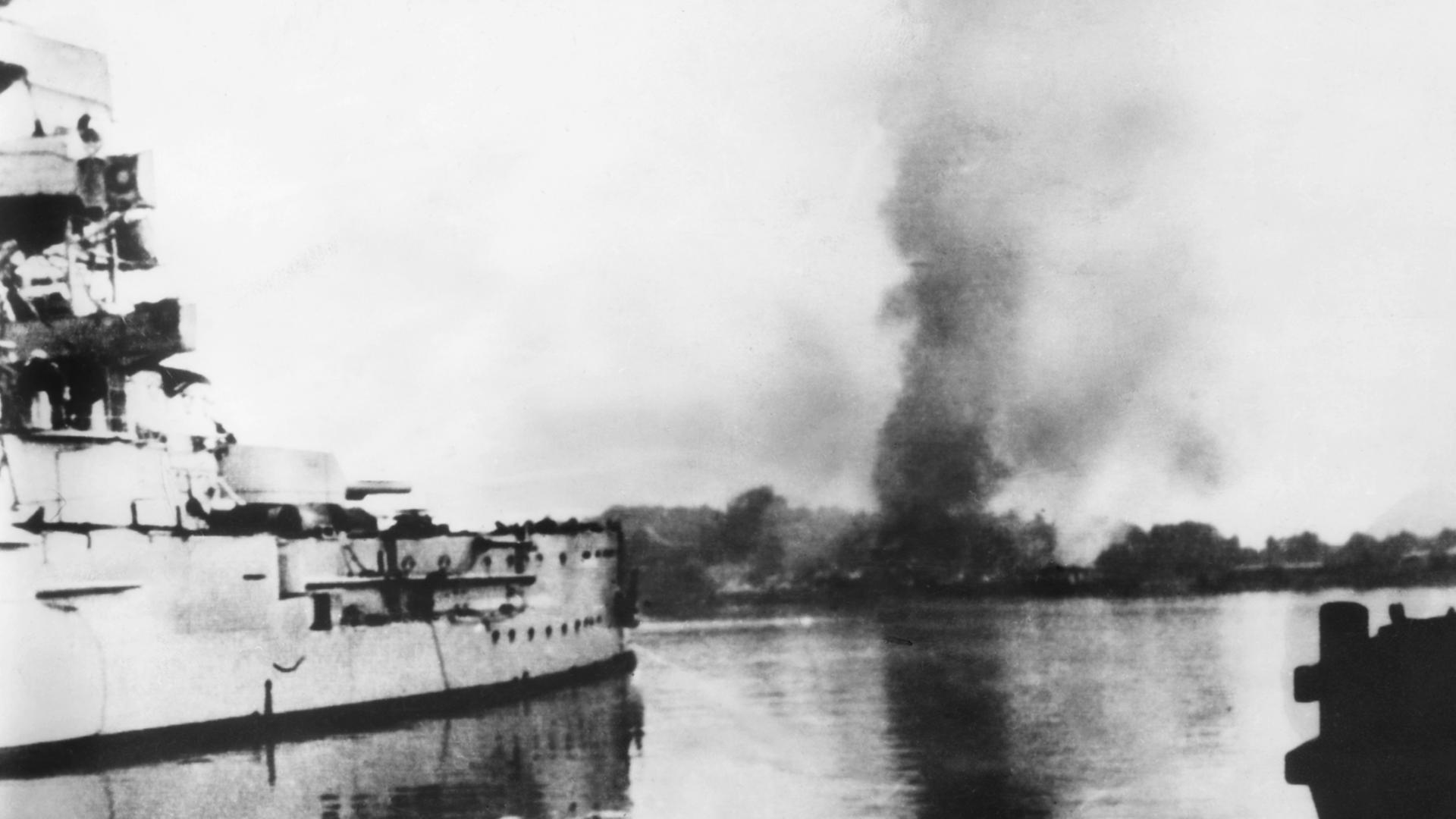Das im Hafenkanal von Neufahrwasser (Danzig) liegende deutsche Linienschiff "SMS Schleswig-Holstein" nimmt am 01.09.1939 das auf der Westerplatte liegende polnische Munitionslager unter Beschuss Das im Hafenkanal von Neufahrwasser (Danzig) liegende deutsche Linienschiff "SMS Schleswig-Holstein" nimmt am 01.09.1939 das auf der Westerplatte liegende polnische Munitionslager unter Beschuss