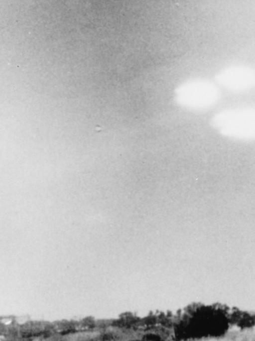 Eine historische schwarz-weiß Fotografie zeigt am Himmel als Ufos bzw. Fliegende Untertassen erscheinende Unbekannte Flugobjekte, die von Shell Alpert, einem Fotograf der US-Küstenwache in Salem, Massachusetts (USA) 16.7.1952 fotografiert wurden.