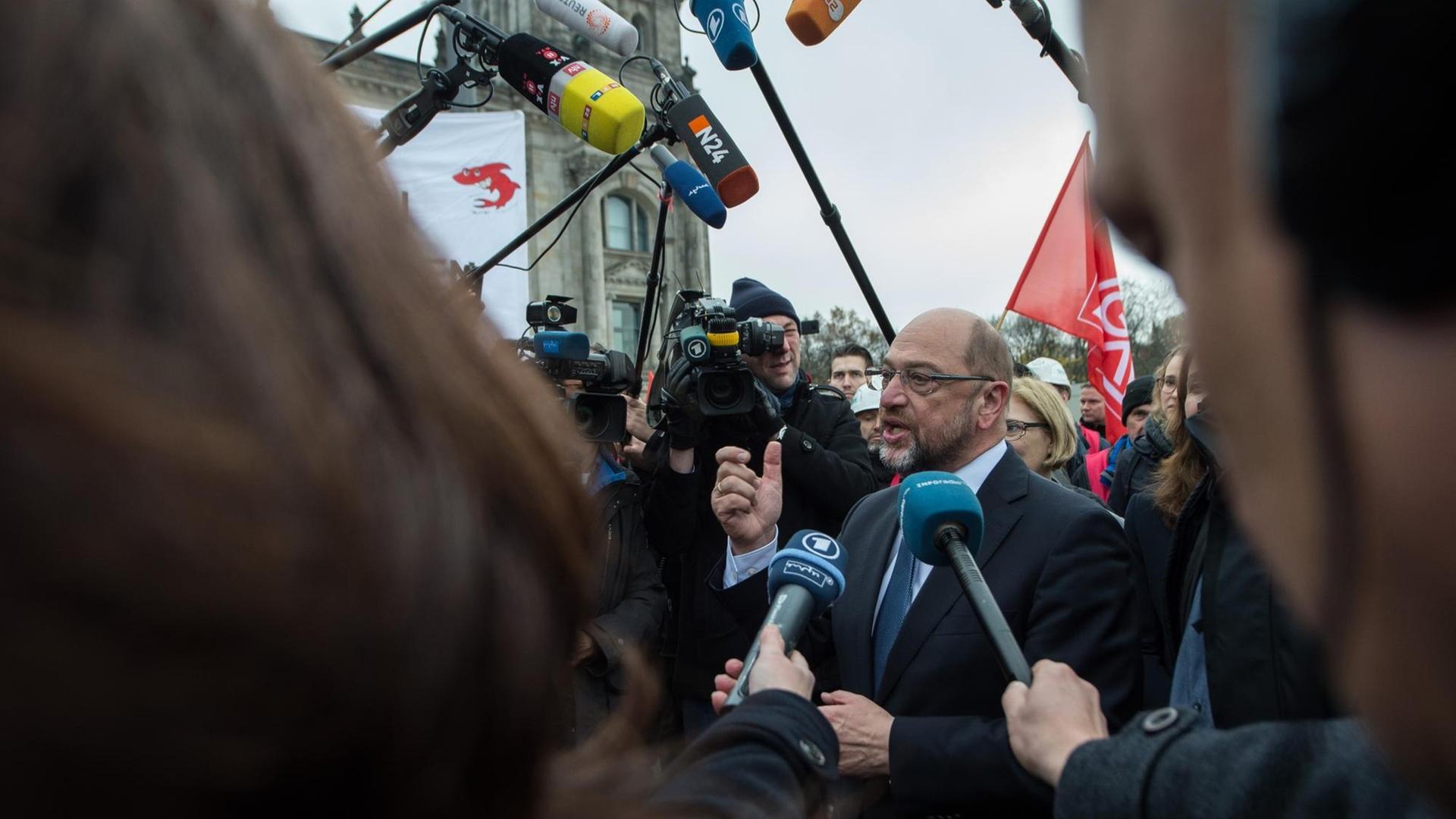 SPD-Chef Schulz spricht bei einem Treffen mit Siemens-Beschäftigten, die vor dem Reichstag in Berlin gegen die geplanten Stellenstreichungen demonstrieren zu Journalisten. SPD-Chef Schulz spricht bei einem Treffen mit Siemens-Beschäftigten, die vor dem Reichstag in Berlin gegen die geplanten Stellenstreichungen demonstrieren zu Journalisten.