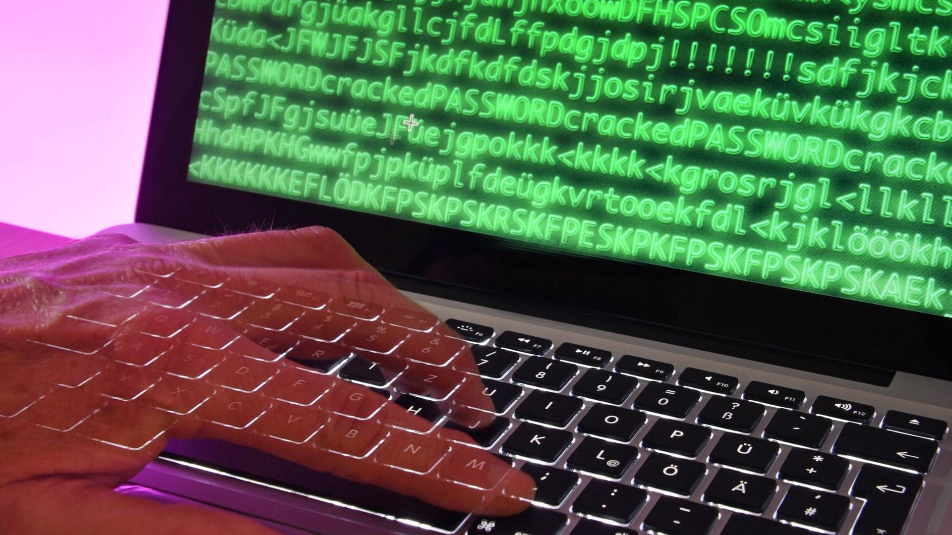 Simulierter Hackerangriff mit Hand und Laptop-Tastatur Simulierter Hackerangriff mit Hand und Laptop-Tastatur