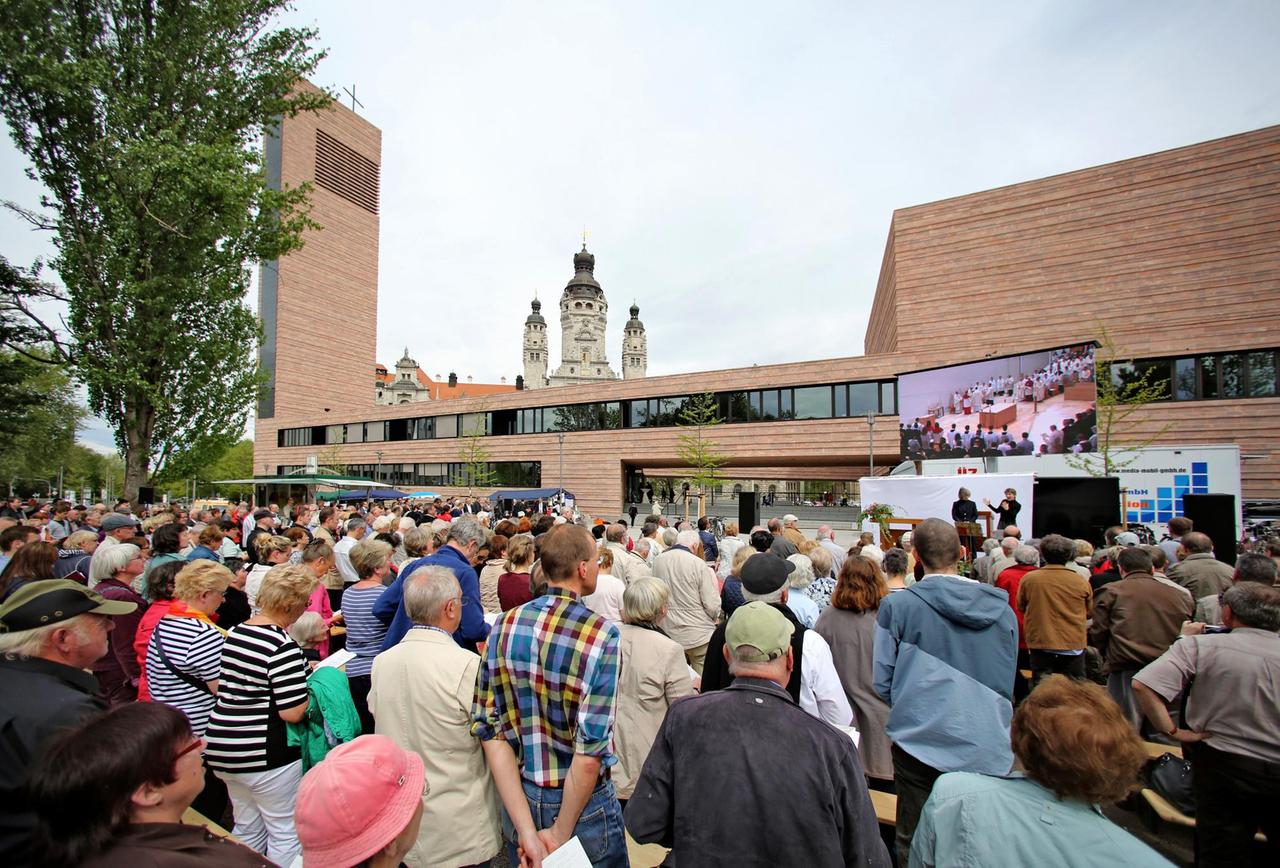 Besucher verfolgen am 09.05.2015 den Festgottesdienst zur Weihe vor der neuen Propsteikirche in Leipzig (Sachsen). Bischof Heiner Koch klopft mit seinem Stab am 09.05.2015 an die Tür der neuen Propsteikirche in Leipzig (Sachsen). Am gleichen Tag wurde das katholische Gotteshaus mit einem Festgottesdienst geweiht. Sie gilt als größter Kirchenneubau im Osten seit dem Mauerfall. Besucher verfolgen am 09.05.2015 den Festgottesdienst zur Weihe vor der neuen Propsteikirche in Leipzig (Sachsen). Bischof Heiner Koch klopft mit seinem Stab am 09.05.2015 an die Tür der neuen Propsteikirche in Leipzig (Sachsen). Am gleichen Tag wurde das katholische Gotteshaus mit einem Festgottesdienst geweiht. Sie gilt als größter Kirchenneubau im Osten seit dem Mauerfall.