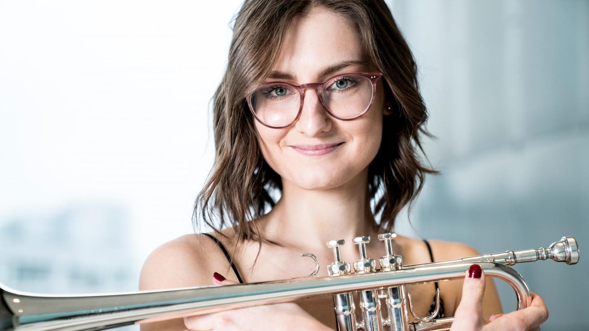 Porträt der Trompeterin mit Instrument vor dem Oberkörper Porträt der Trompeterin mit Instrument vor dem Oberkörper