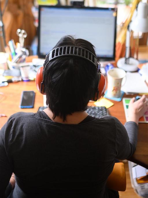 Eine Frau arbeitet im Homeoffice an ihrem Schreibtisch