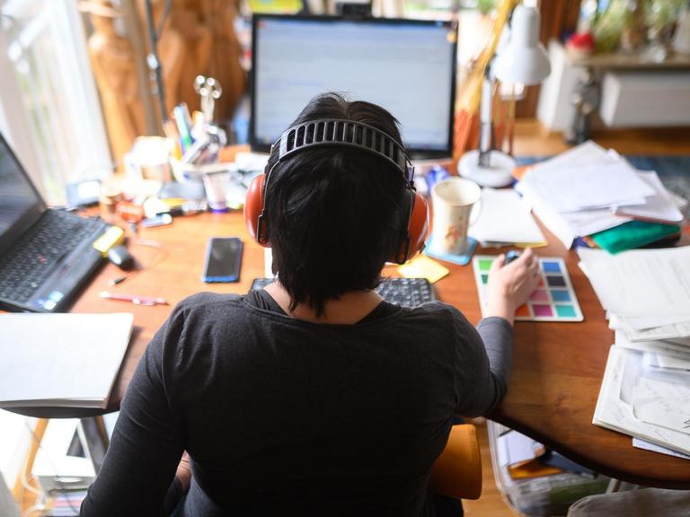 Eine Frau arbeitet im Homeoffice an ihrem Schreibtisch