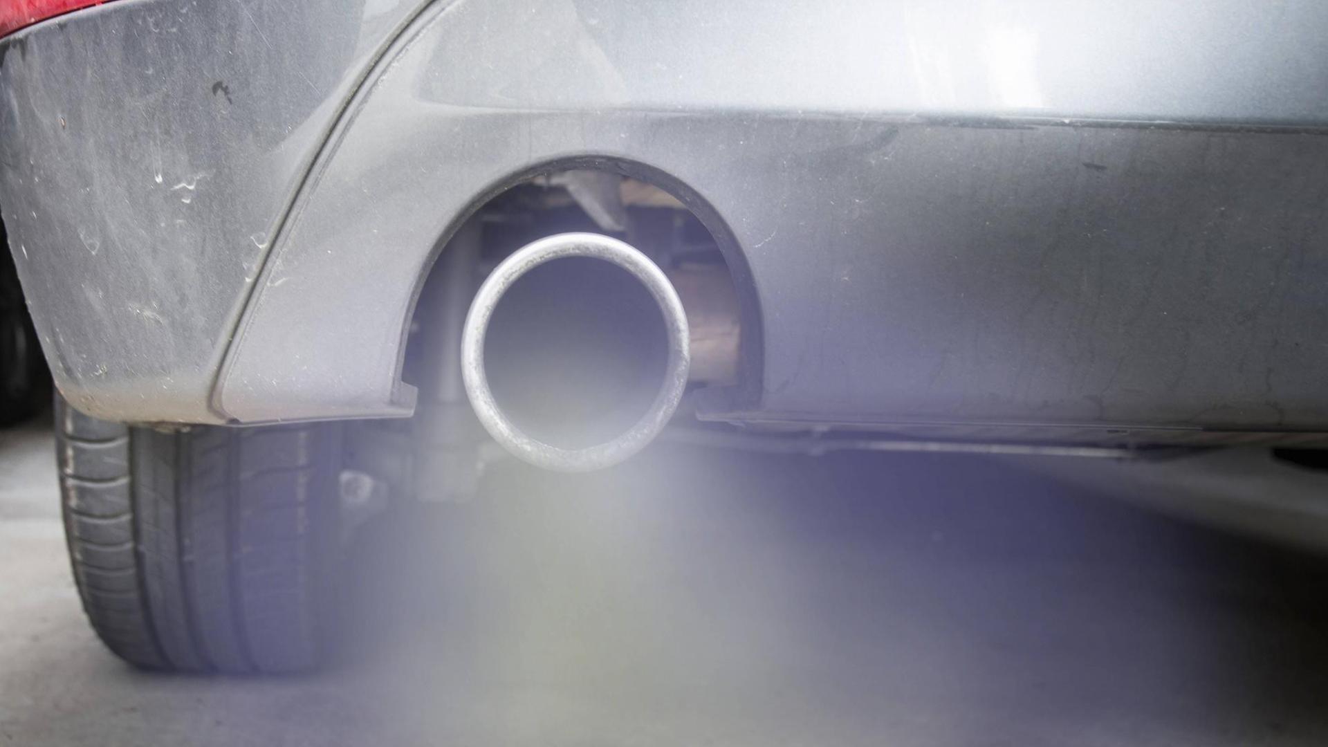 Rauch strömt aus dem Auspuff eines Autos Rauch strömt aus dem Auspuff eines Autos