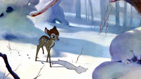 Allein läuft Bambi durch einen verschneiten Wald.