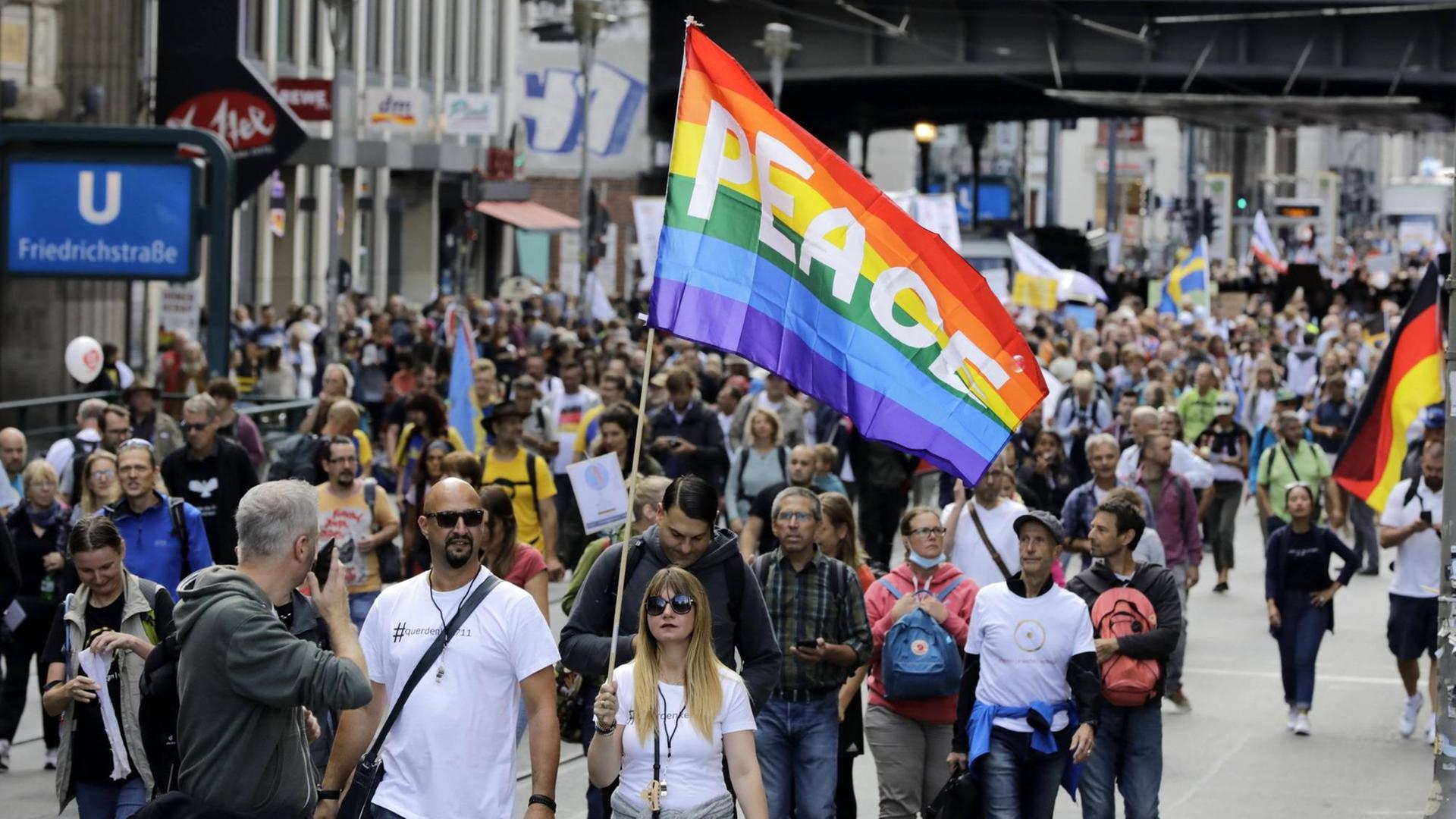 Demonstranten auf der Friedrichstraße in Berlin, eine Frau hält eine Friedensfahne hoch. Demonstranten auf der Friedrichstraße in Berlin, eine Frau hält eine Friedensfahne hoch.
