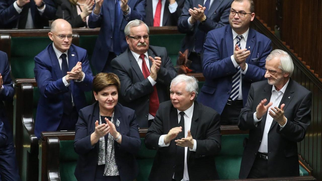 Polens Ministerpräsidentin Beata Szydlo und PiS-Chef Jaroslaw Kaczynski applaudieren nach der Verabschiedung des umstrittenen Gesetzes über das Verfassungsgericht. Polens Ministerpräsidentin Beata Szydlo und PiS-Chef Jaroslaw Kaczynski applaudieren nach der Verabschiedung des umstrittenen Gesetzes über das Verfassungsgericht.
