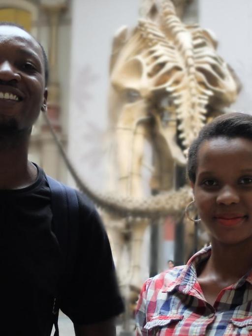 Erica Mela und Frank James Wajega vor dem Skelett des Dinosauriers im Naturkundemuseum.
