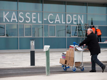 Ein Mann transportiert am Flughafen Kassel-Calden (Hessen) Kisten auf einem Trolley. Nach rund 15 Jahren des Planens, Prüfens und Bauens wird am Donnerstag (04.04.2013) der neue Flughafen Kassel-Calden eröffnet.