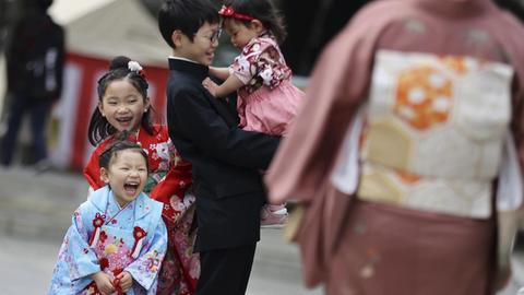 Drei Mädchen und ein Junge auf einer Straße in Tokio