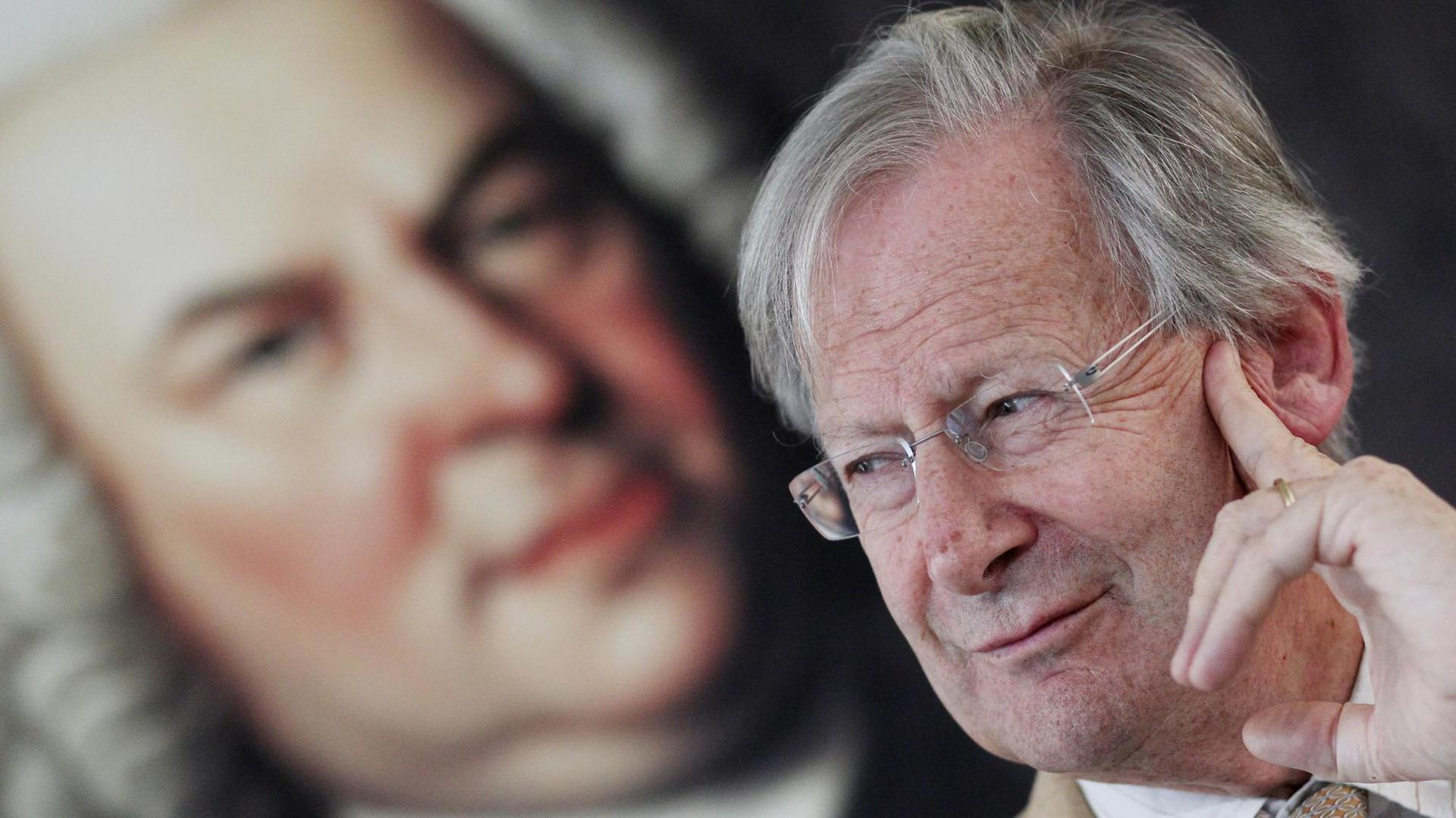 Sir John Eliot Gardiner, Präsident der Stiftung Bach-Archiv Leipzig, sitzt am 13.06.2014 bei einer Pressekonferenz vor einem Porträt des Komponisten Johann Sebastian Bach. Vom 13. bis 22. Juni 2014 findet das Bachfest Leipzig statt, das diesmal das Werk des zweitältesten Bach-Sohnes, Carl Philipp Emanuel Bach in den Mittelpunkt rückt. Bei rund 110 Veranstaltungen werden insgesamt etwa 70.000 Besucher erwartet. Foto: Sebastain Willnow/dpa Sir John Eliot Gardiner, Präsident der Stiftung Bach-Archiv Leipzig, sitzt am 13.06.2014 bei einer Pressekonferenz vor einem Porträt des Komponisten Johann Sebastian Bach. Vom 13. bis 22. Juni 2014 findet das Bachfest Leipzig statt, das diesmal das Werk des zweitältesten Bach-Sohnes, Carl Philipp Emanuel Bach in den Mittelpunkt rückt. Bei rund 110 Veranstaltungen werden insgesamt etwa 70.000 Besucher erwartet. Foto: Sebastain Willnow/dpa