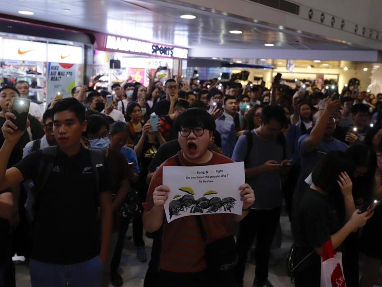 Demonstranten in einem Hong Konger Shopping Center singen das Lied "Glory to Hong Kong"
