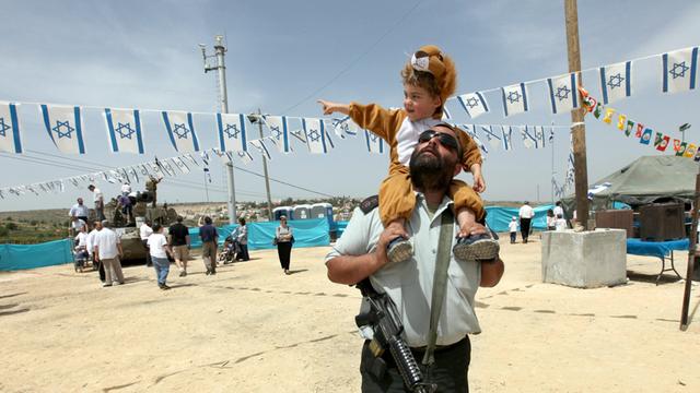Ein Offizier der israelischen Armee trägt seinen Sohn auf den Schultern während einer Veranstaltung des Militärs am 62. Unabhängigkeitstages in der jüdischen Siedlung Efrat in der Westbank am 20. April 2010.