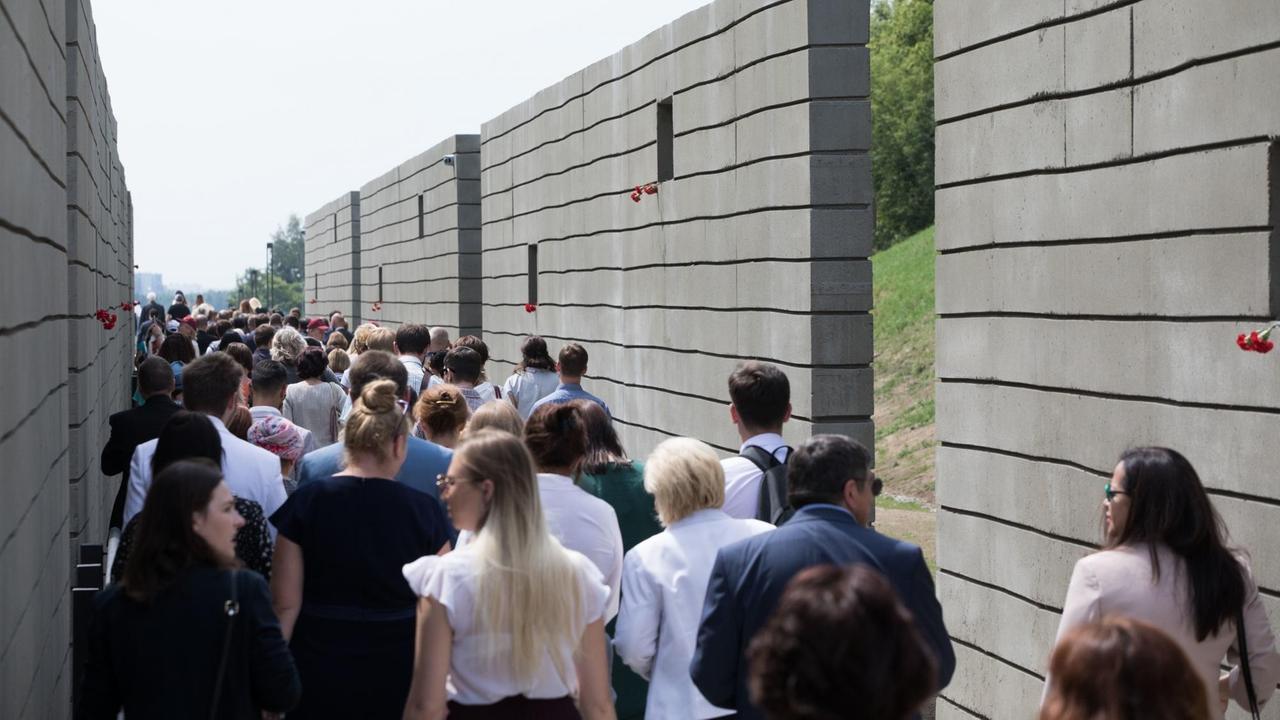 29.06.2018, Minsk, Weißrussland: Zahlreiche Menschen gehen nach der Eröffnung der Gedenkstätte Malyj Trostenez durch die sogenannten "Waggons". 