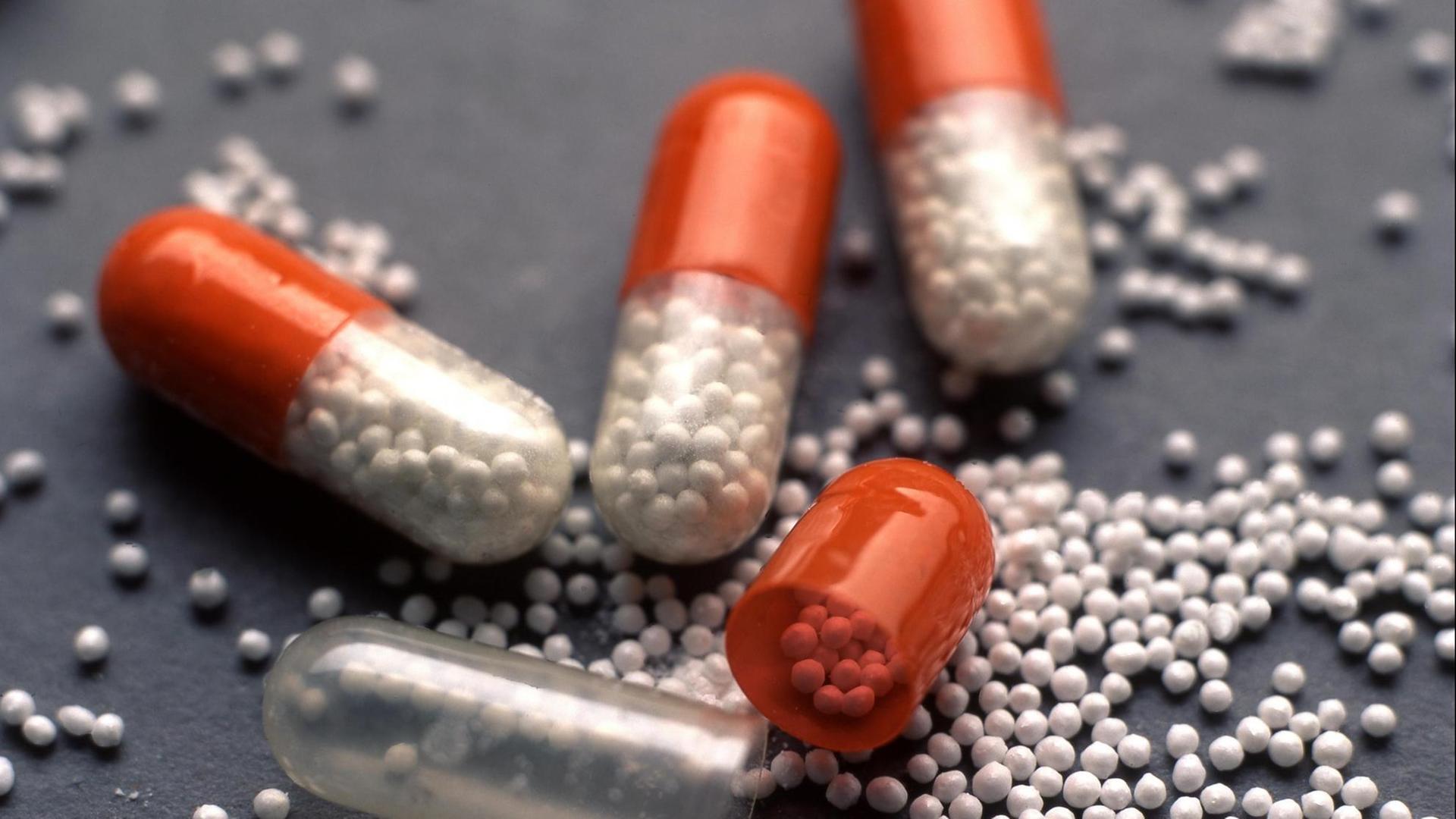 Das Foto zeigt mehrere Kapseln, die jeweils viele kleine Pillen beinhalten.
