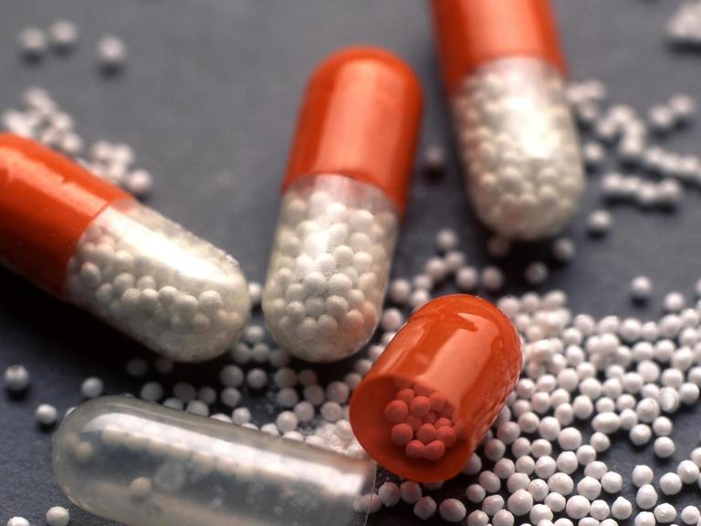 Das Foto zeigt mehrere Kapseln, die jeweils viele kleine Pillen beinhalten.