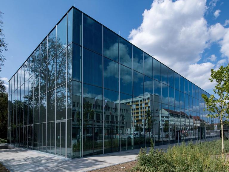 Das neue Bauhaus Museum. Ein spitzes Gebäude aus Glas, in dem sich die umliegenden Häuser spiegeln.