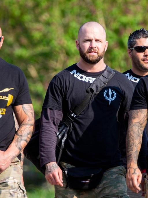 Vier Männer mit durchtrainierten Körpern auf ihren T-Shirts steht "Noricum", der Name ihrer Kampfsportgruppe
