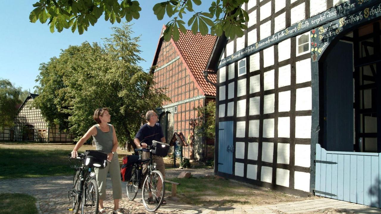In dem Rundlingsdorf Satemin (Kr. Lüchow-Dannenberg), typisch für das Wendland, schauen sich zwei Fahrrad-Touristen aus dem Kreis Gifhorn eines der im Kreis angeordneten Fachwerkhäuser an. Aufnahme vom 18.8.2003. Das Wendland ist aufgrund seines gut verzweigten Landwirtschaftswegenetzes, des geringen Verkehrsaufkommens und der malerischen Dörfer ein beliebtes Ausflugs- und Reiseziel für Radfahrer. | Verwendung weltweit In dem Rundlingsdorf Satemin (Kr. Lüchow-Dannenberg), typisch für das Wendland, schauen sich zwei Fahrrad-Touristen aus dem Kreis Gifhorn eines der im Kreis angeordneten Fachwerkhäuser an. Aufnahme vom 18.8.2003. Das Wendland ist aufgrund seines gut verzweigten Landwirtschaftswegenetzes, des geringen Verkehrsaufkommens und der malerischen Dörfer ein beliebtes Ausflugs- und Reiseziel für Radfahrer. | Verwendung weltweit