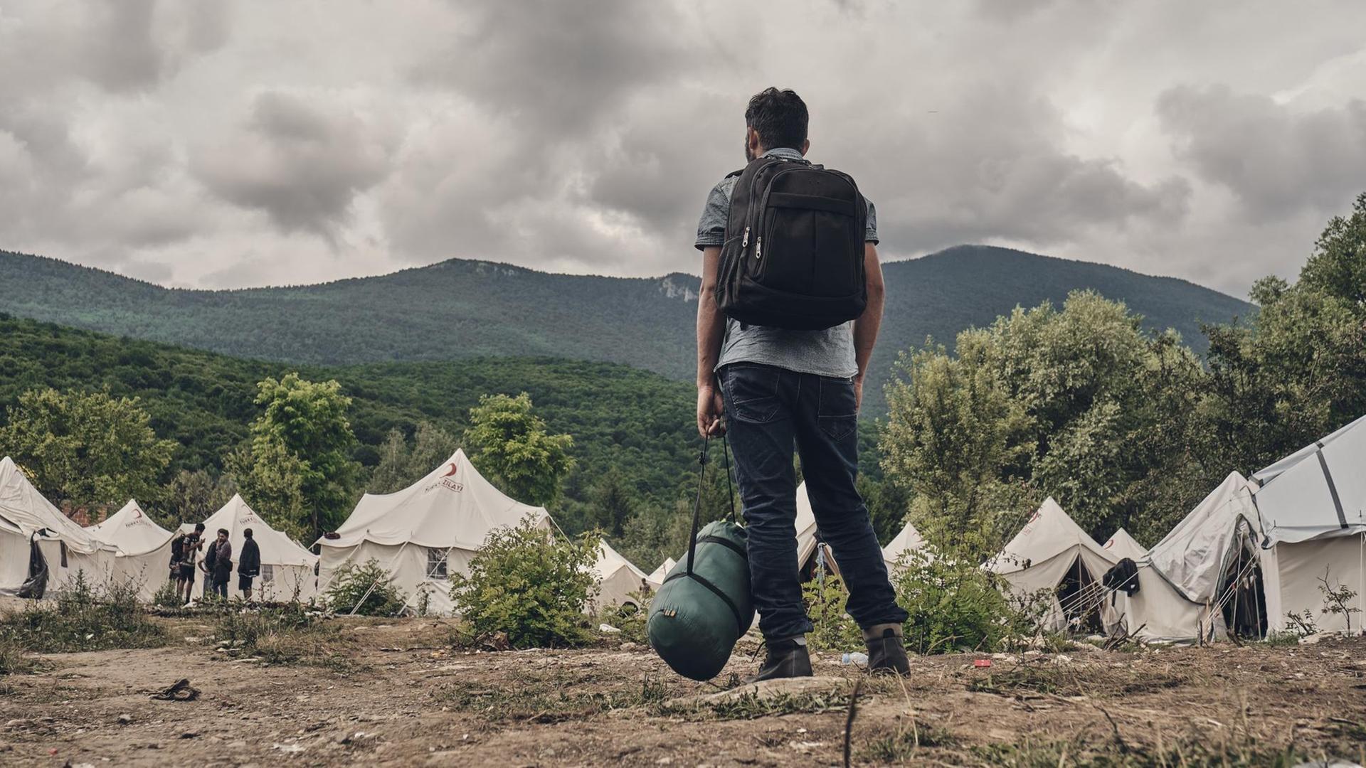 Ein Mann kommt im Flüchtlingslager Vučjak bei der bosnischen Stadt Bihac an. Hier wurde einst Müll deponiert. Ein Mann kommt im Flüchtlingslager Vučjak bei der bosnischen Stadt Bihac an. Hier wurde einst Müll deponiert.