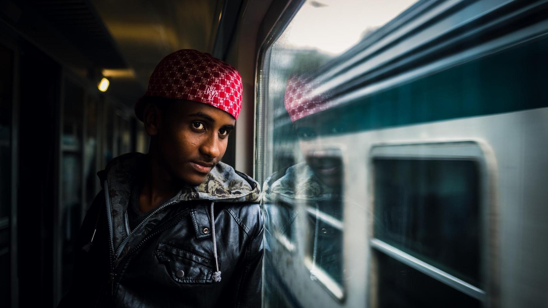 Beschreibung:Meron aus Eritrea blickt am 19.08.2015 im Zug von Rom nach Bozen (Italien) aus dem Fenster. Auf der Flucht vor Hunger Krieg und Verfolgung suchen viele Flüchtlinge das Glück in Europa