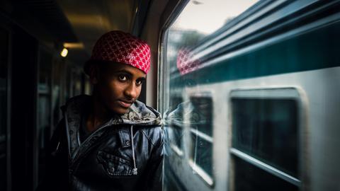 Ein Eriträer schaut aus dem Fenster eines Zuges in Italien. Auf der Flucht vor Hunger Krieg und Verfolgung suchen viele Flüchtlinge das Glück in Europa