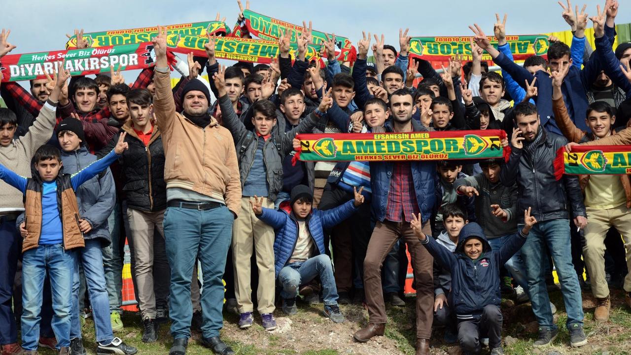 Anhänger des kurdischen Fußballvreins Amedspor in Diyarbakir halten ihre Fan-Schals hoch