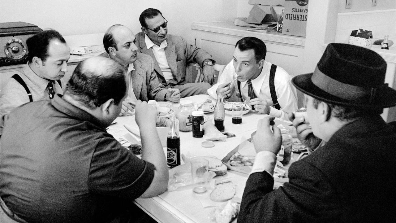 Frank Sinatra beim Essen am Tisch mit fünf anderen Männern