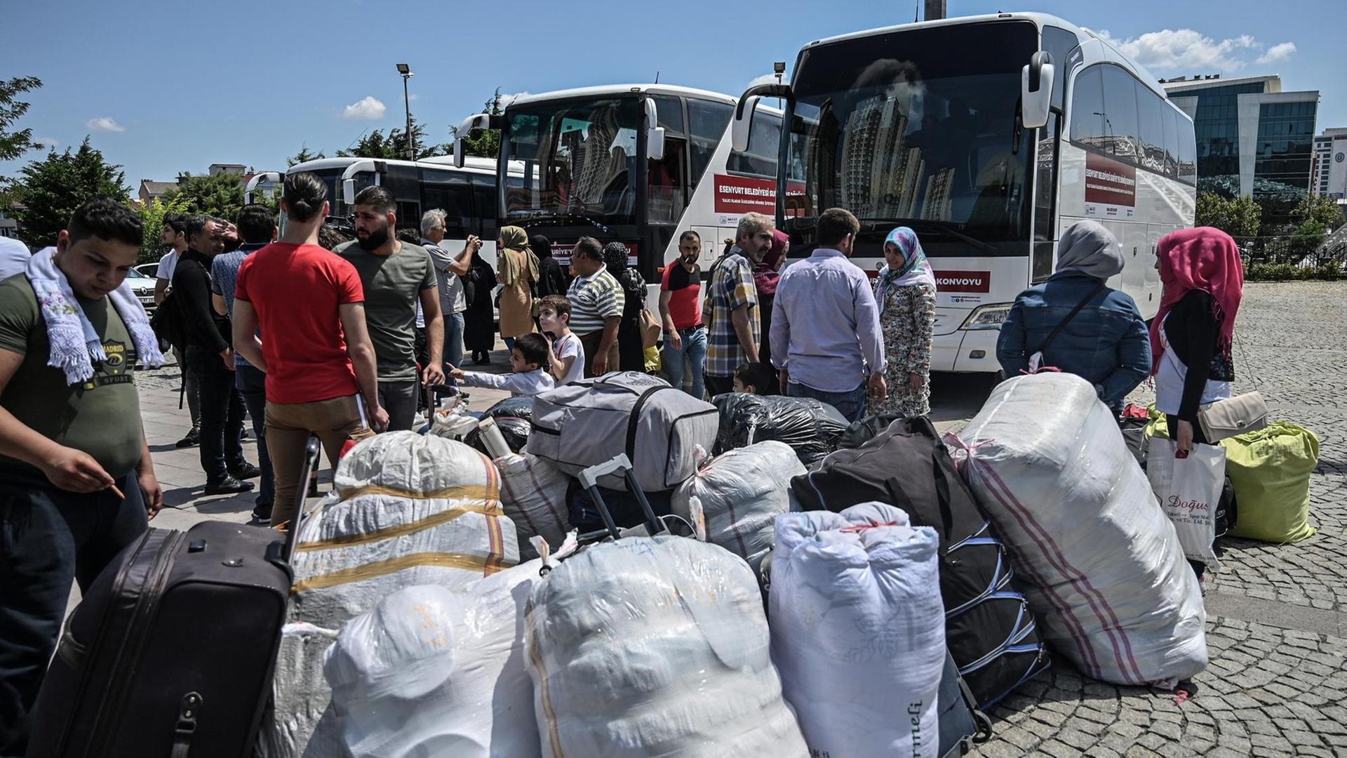Syrische Flüchtlingsfamilien warten mit ihrem Gepäck neben mehreren Reisebussen, die sie vom türkischen Ort Esenyurt zurück nach Syrien bringen sollen, am 6. August 2019. Syrische Flüchtlingsfamilien warten mit ihrem Gepäck neben mehreren Reisebussen, die sie vom türkischen Ort Esenyurt zurück nach Syrien bringen sollen, am 6. August 2019.