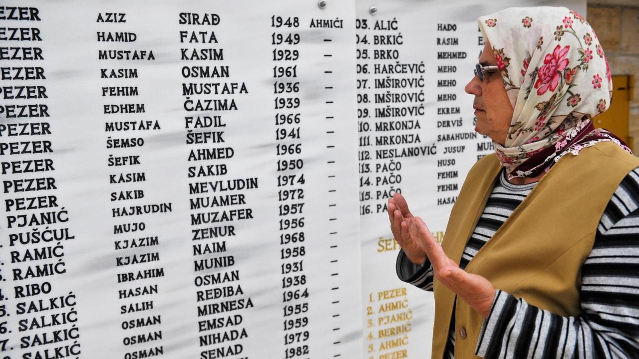 VITEZ, BOSNIA AND HERZEGOVINA - APRIL 16: A woman prays at cemetery next to victims' names during the 23th anniversary of Ahmici massacre in Vitez, Bosnia and Herzegovina on April 16, 2014. In Ahmici, Croatian forces killed 116 Bosnian civilians in April 1993, during the short period in the war when Bosnians and Croatians fought each other in Vitez, central Bosnia and Herzegovina. Samir Yordamovic / Anadolu Agency | Keine Weitergabe an Wiederverkäufer. VITEZ, BOSNIA AND HERZEGOVINA - APRIL 16: A woman prays at cemetery next to victims' names during the 23th anniversary of Ahmici massacre in Vitez, Bosnia and Herzegovina on April 16, 2014. In Ahmici, Croatian forces killed 116 Bosnian civilians in April 1993, during the short period in the war when Bosnians and Croatians fought each other in Vitez, central Bosnia and Herzegovina. Samir Yordamovic / Anadolu Agency | Keine Weitergabe an Wiederverkäufer.