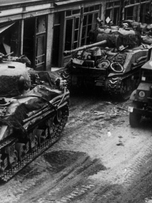 Panzer der Alliierten fahren beim Vormarsch im März 1945 durch die Straßen der Stadt Kevelear.