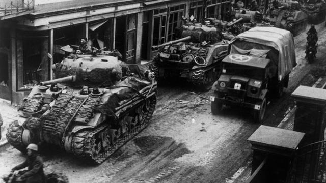 Panzer der Alliierten fahren beim Vormarsch im März 1945 durch die Straßen der Stadt Kevelear.