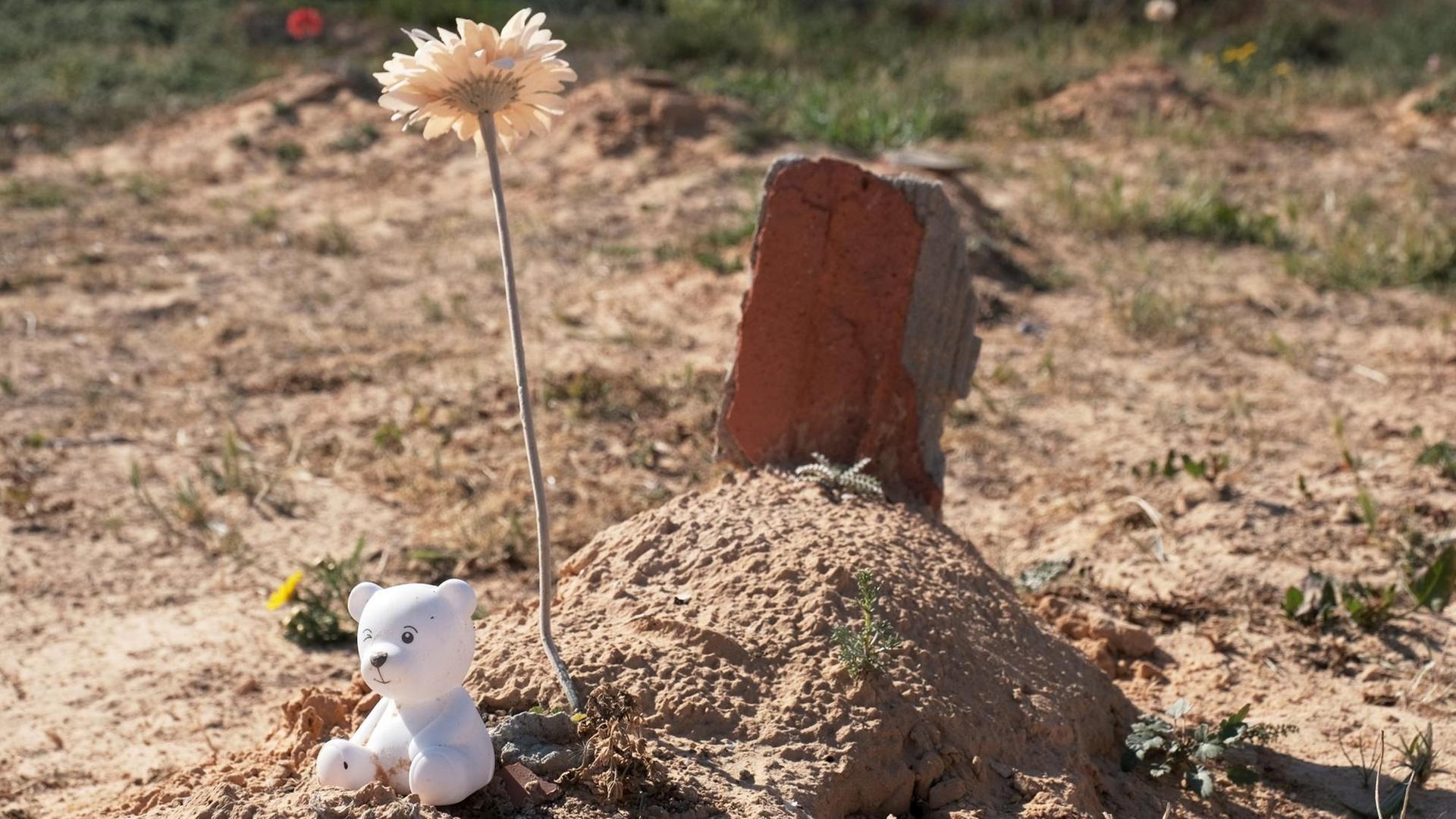 Ein kleines Grab mit Blume und Teddy auf dem "Friedhof des Unbekannten" Ein kleines Grab mit Blume und Teddy auf dem "Friedhof des Unbekannten"