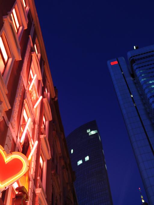 Unweit der Bürohochhäuser leuchtet im Bahnhofsviertel in Frankfurt am Main die Leuchtreklame eines Eros-Centers.