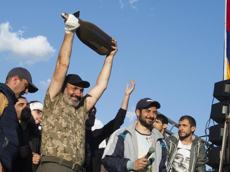 Nikol Paschinjan (M), Anführer der Proteste gegen den armenischen Ministerpräsidenten Sargsjan, jubelt mit einer großen Flasche Sekt in den Händen mit anderen Demonstranten, nachdem Armeniens Ministerpräsident Sargsjan zurückgetreten ist.