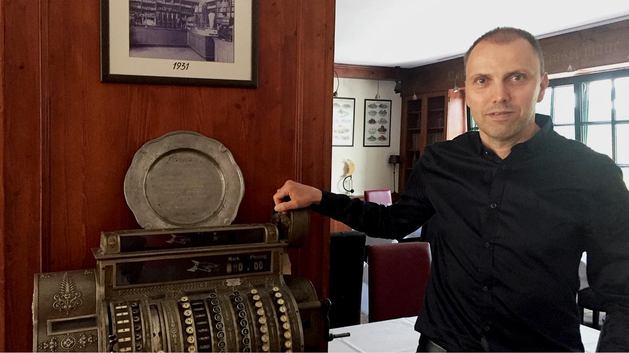 Michael Hermerschmidt steht im Gastraum des Hotels vor einer historischen Kasse. Michael Hermerschmidt steht im Gastraum des Hotels vor einer historischen Kasse.