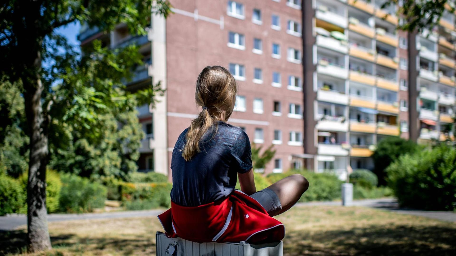 Ein Kind sitzt vor einem Plattenbau in Leipzig-Gruenau. 31. Juli 2020. Ein Kind sitzt vor einem Plattenbau in Leipzig-Gruenau. 31. Juli 2020.