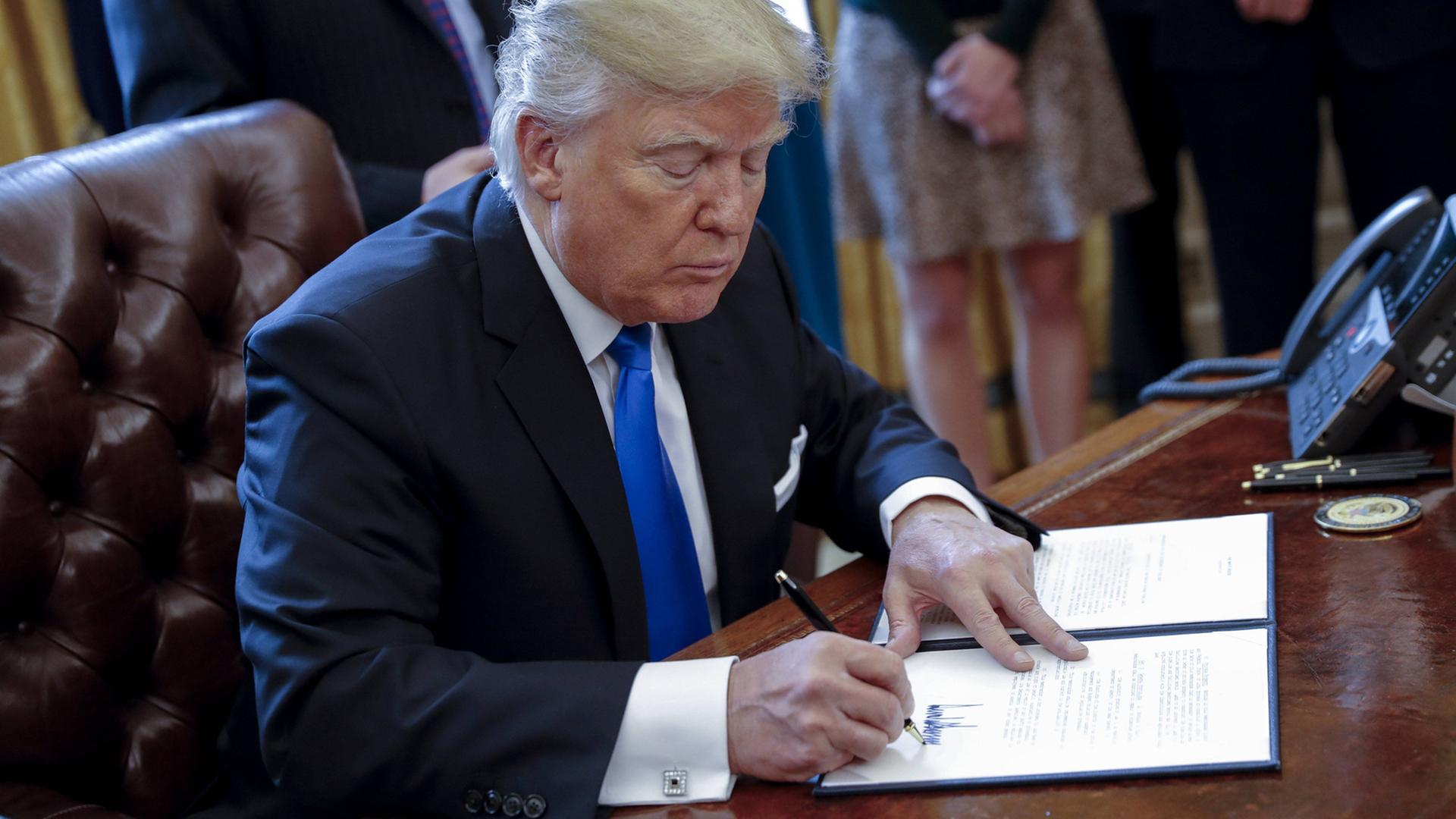 US-Präsident Donald Trump unterzeichnet ein Dekret, das den Weiterbau der umstrittenen Dakota Access Pipeline genehmigt. Die Pipeline führt durch heilige Stätten der Sioux-Indianer. US-Präsident Donald Trump unterzeichnet ein Dekret, das den Weiterbau der umstrittenen Dakota Access Pipeline genehmigt. Die Pipeline führt durch heilige Stätten der Sioux-Indianer.
