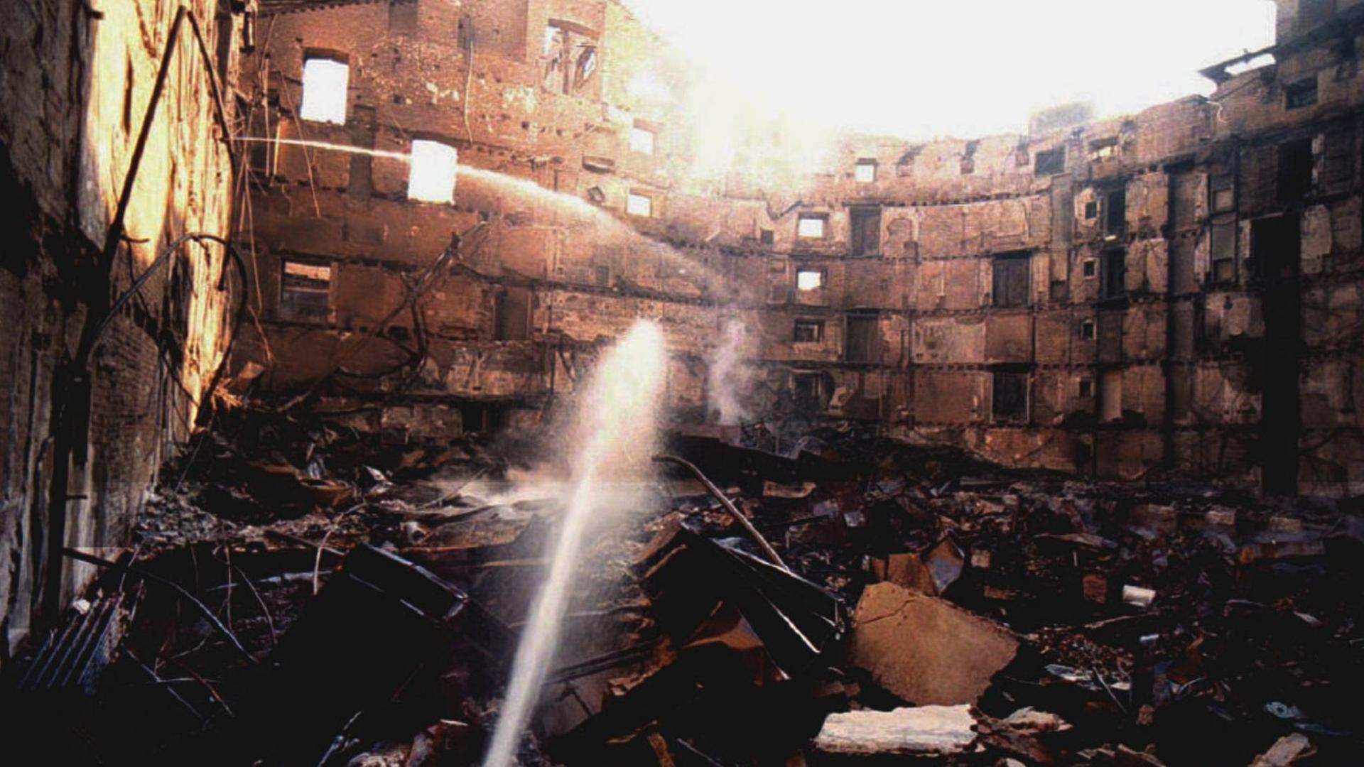 Ein Farbfoto zeigt zwei Wasserstrahl die den gänzlich verkohlten Innenraum des Bis auf die Außenmauern niedergebrannten Opernhauses La Fenice in Venedig Ein Farbfoto zeigt zwei Wasserstrahl die den gänzlich verkohlten Innenraum des Bis auf die Außenmauern niedergebrannten Opernhauses La Fenice in Venedig