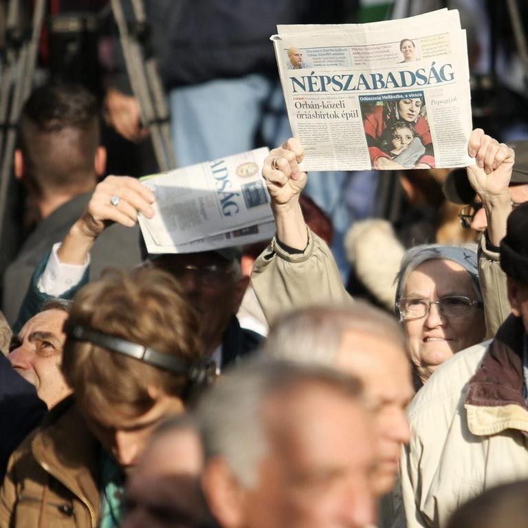 Das Bild zeigt für die Pressefreiheit protestierende Regierungsgegner in der ungarischen Hauptstadt Budapest. Einige halten Ausgaben der inzwischen eingestellten Tageszeitung "Nepszabadsag" in die Höhe.