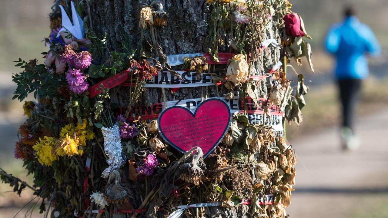 Blumen und Trauerschmuck hängen am 05.12.2016 in Freiburg (Baden-Württemberg) an einem Baum an der Dreisam. Ein unbegleiteter minderjähriger Flüchtling wird verdächtigt, dort eine 19 Jahre alte Studentin umgebracht zu haben.