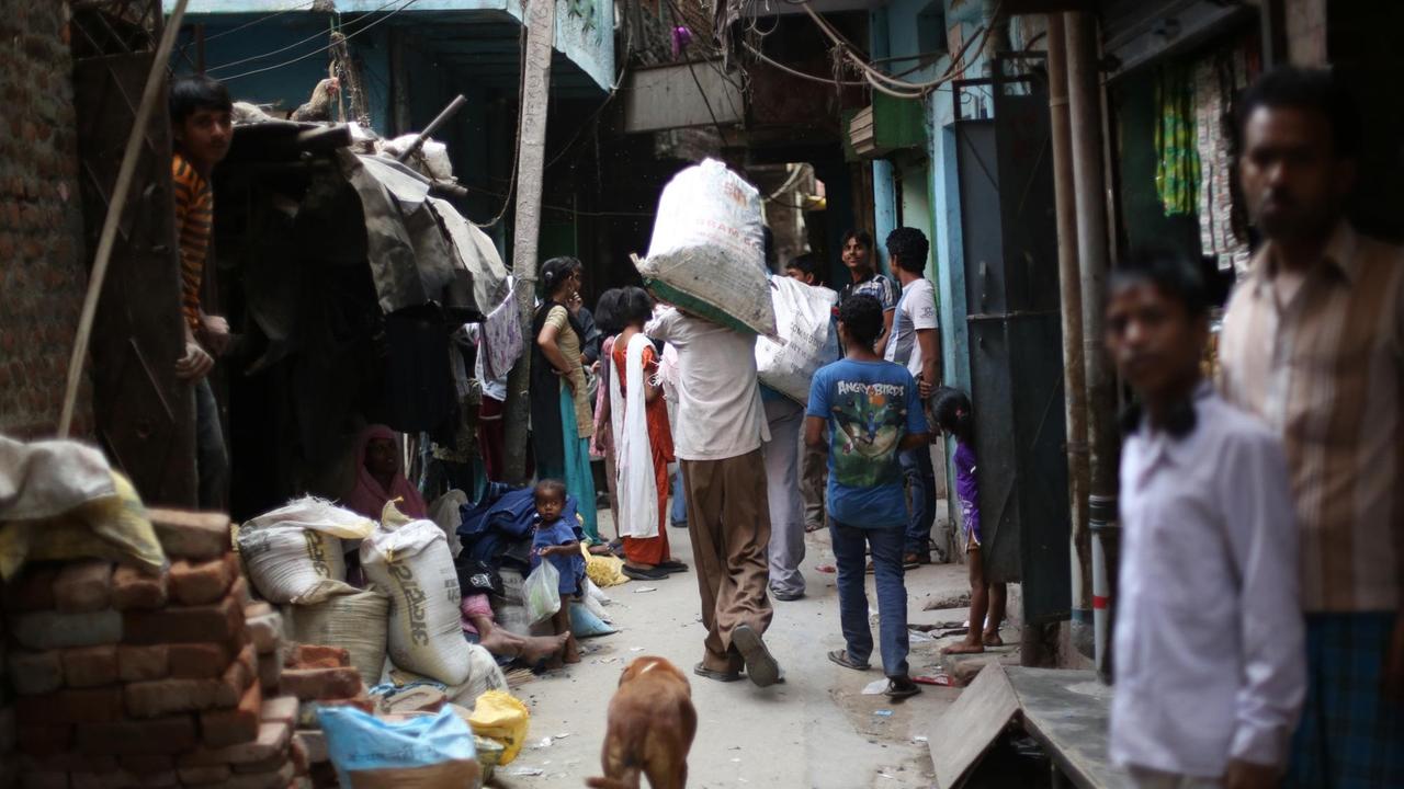 Bewohner gehen zwischen Häusern in dem Slum Shastri Park am Fluß Yamuna im Osten von Delhi, Indien. In der 30-40 Jahre alten Siedlung Shastri Park nahe der gleichnamigen Metrostation leben ca. 18.000 Menschen auf engstem Raum. Bewohner gehen zwischen Häusern in dem Slum Shastri Park am Fluß Yamuna im Osten von Delhi, Indien. In der 30-40 Jahre alten Siedlung Shastri Park nahe der gleichnamigen Metrostation leben ca. 18.000 Menschen auf engstem Raum.