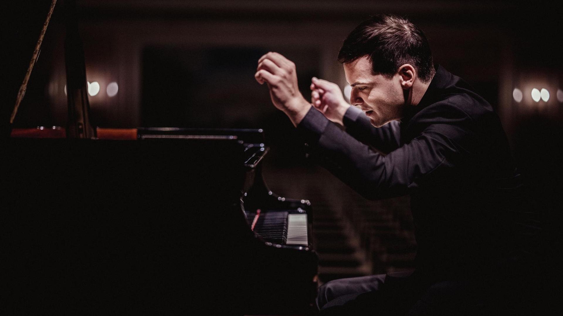  Der Pianist Francesco Piemontesi sitzt an einem Flügel und gestikuliert