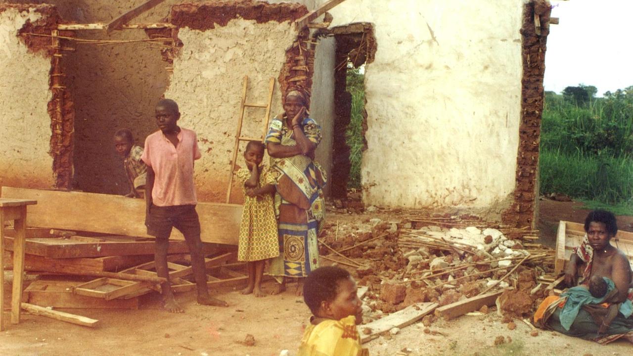Ein zerstörtes Haus nach der Vertreibung der Dorfbewohner in Mubende 2001. Die Mauern sind eingerissen. Kinder und Frauen gucken fassungslos. Ein zerstörtes Haus nach der Vertreibung der Dorfbewohner in Mubende 2001. Die Mauern sind eingerissen. Kinder und Frauen gucken fassungslos.