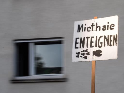 Ein Schild mit der Aufschrift "Miethaie enteignen" wird auf einer Demonstration gegen die Räumung von zwei Wohnungen in Stuttgart hochgehalten.