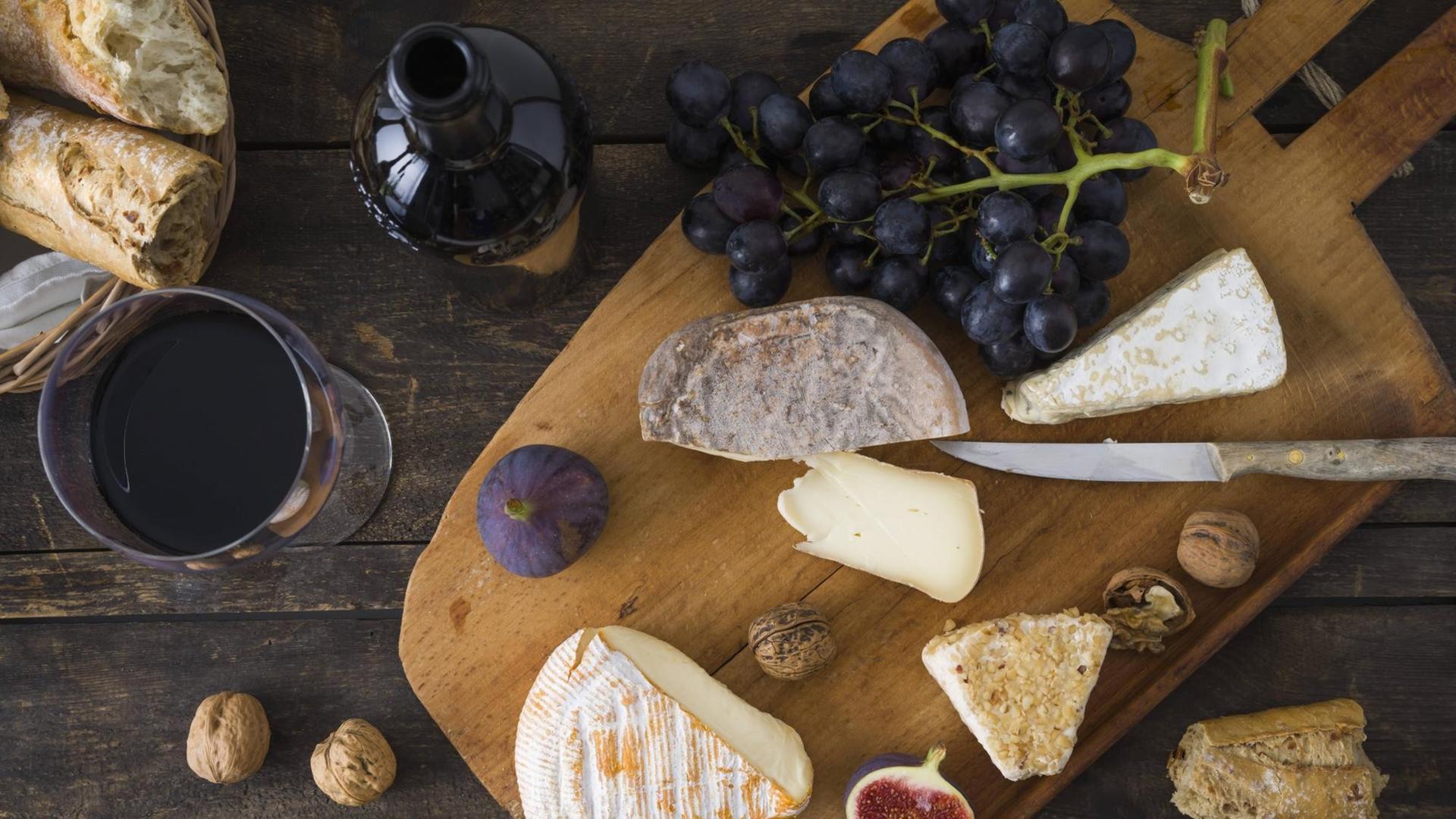 Käseplatte mit Walnüssen, Trauben, Feigen, Brot und Rotwein Käseplatte mit Walnüssen, Trauben, Feigen, Brot und Rotwein