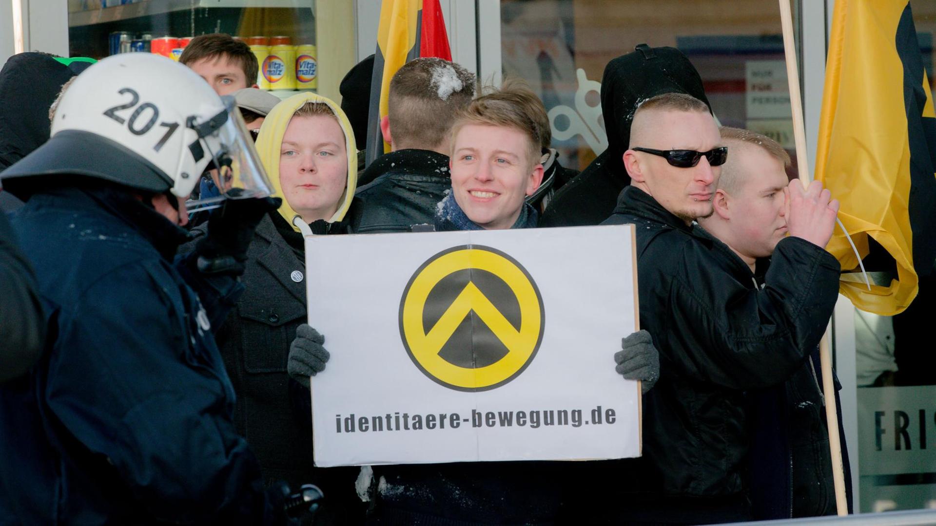 Mitglieder der antiislamischen German Defense League (GDL) halten bei einer Anti-Moschee-Kundgebung im März 2013 in Hamburg ein Schild mit der Aufschrift "identitaere-bewegung.de". Die GDL wollte gegen den geplanten Umbau der ehemaligen Kapernaum-Kirche in eine Moschee protestieren. Foto: Markus Scholz/dpa Mitglieder der antiislamischen German Defense League (GDL) halten bei einer Anti-Moschee-Kundgebung im März 2013 in Hamburg ein Schild mit der Aufschrift "identitaere-bewegung.de". Die GDL wollte gegen den geplanten Umbau der ehemaligen Kapernaum-Kirche in eine Moschee protestieren. Foto: Markus Scholz/dpa