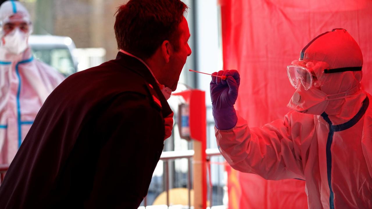 Einem Mitarbeiter der Berufsfeuerwehr Köln wird im dritten Infektionsschutzzentrum der Stadt Köln mit einem Stäbchen ein Abstrich für einen Test auf den Coronavirus entnommen. Einem Mitarbeiter der Berufsfeuerwehr Köln wird im dritten Infektionsschutzzentrum der Stadt Köln mit einem Stäbchen ein Abstrich für einen Test auf den Coronavirus entnommen.