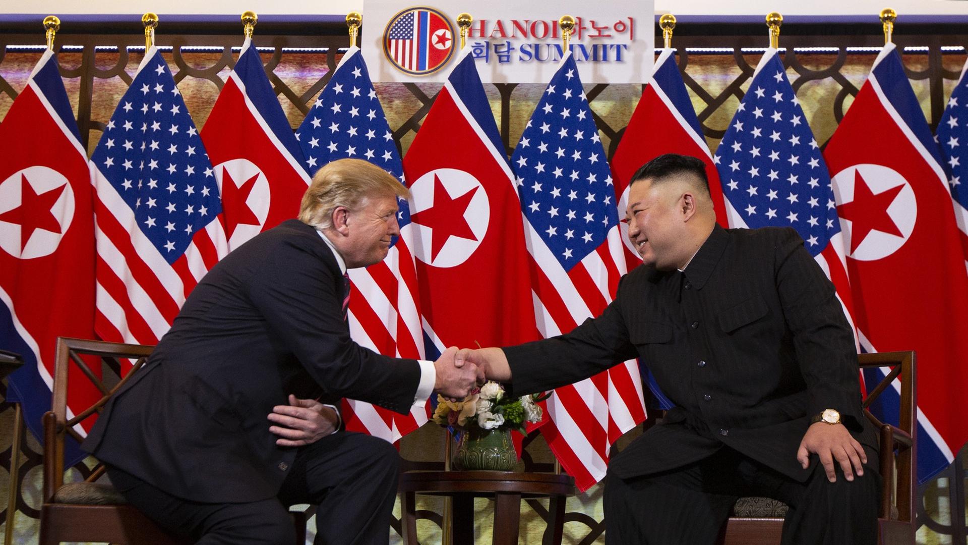 US-Präsident Donald Trump und der nordkoreanische Diktator Kim Jong Un reichen sich die Hände und lächeln sich an. US-Präsident Donald Trump und der nordkoreanische Diktator Kim Jong Un reichen sich die Hände und lächeln sich an.